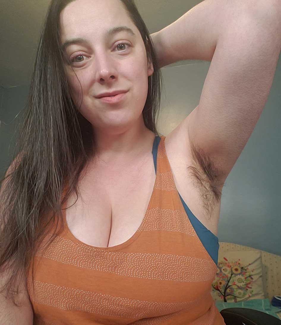 A busty woman with very hairy armpits.